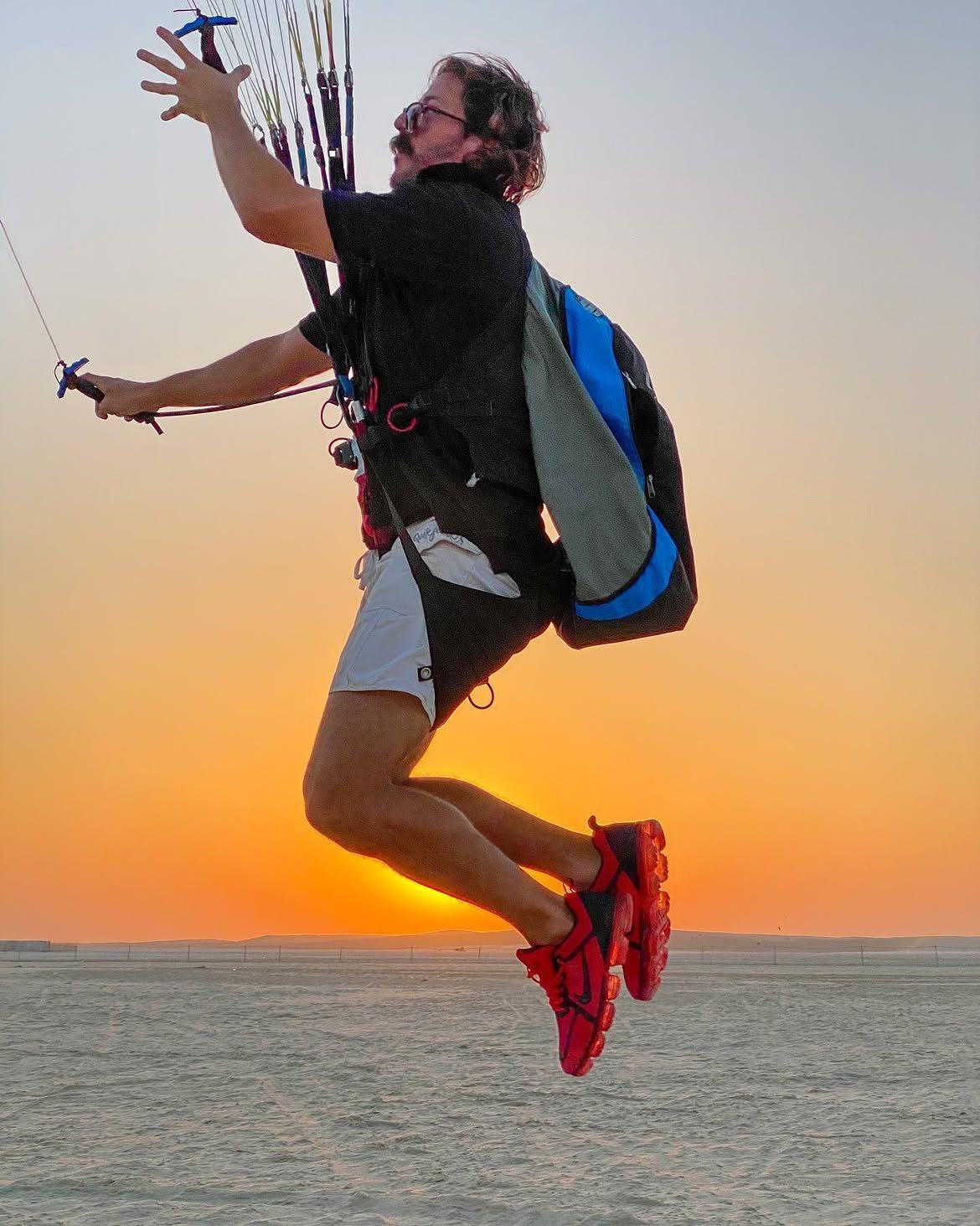 Javi launching at sunset, arms up to the risers