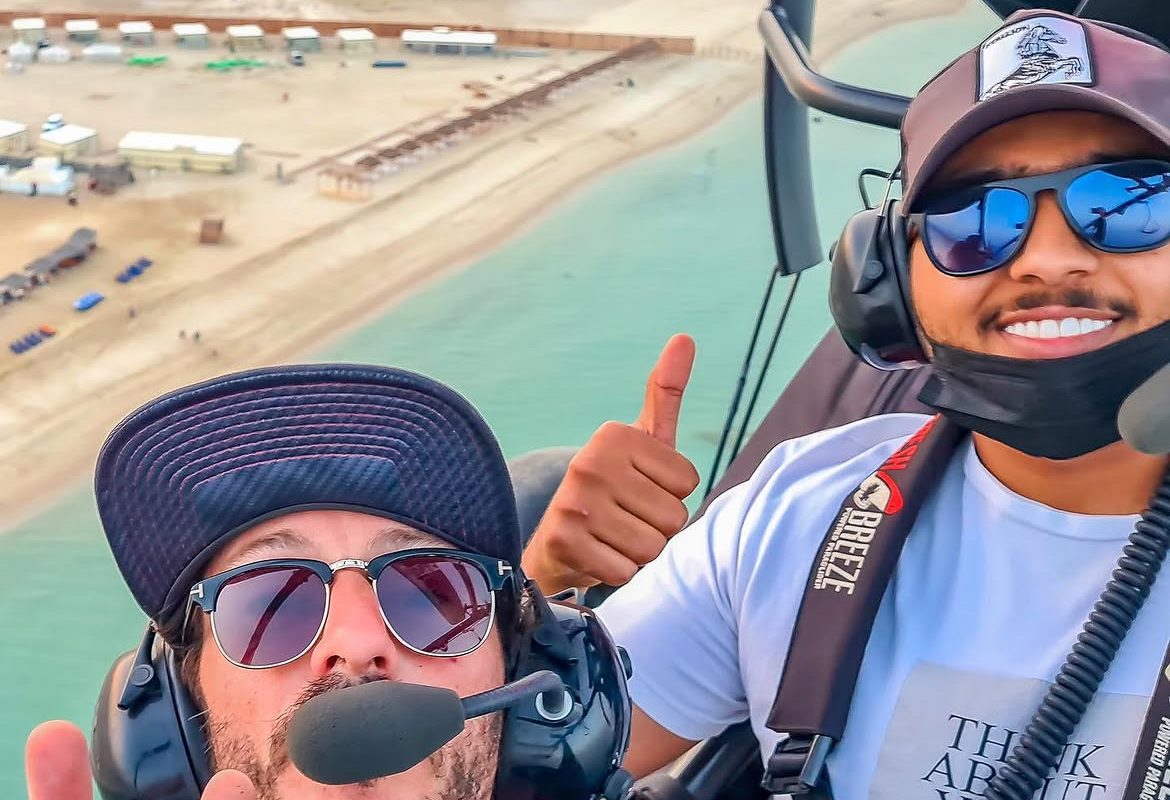 Javi and a passenger on a paratrike, both giving a thumbs up