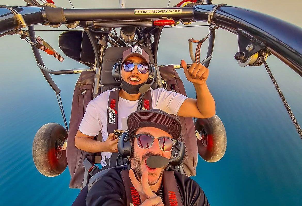 Javi flying a paratrike with a young passenger